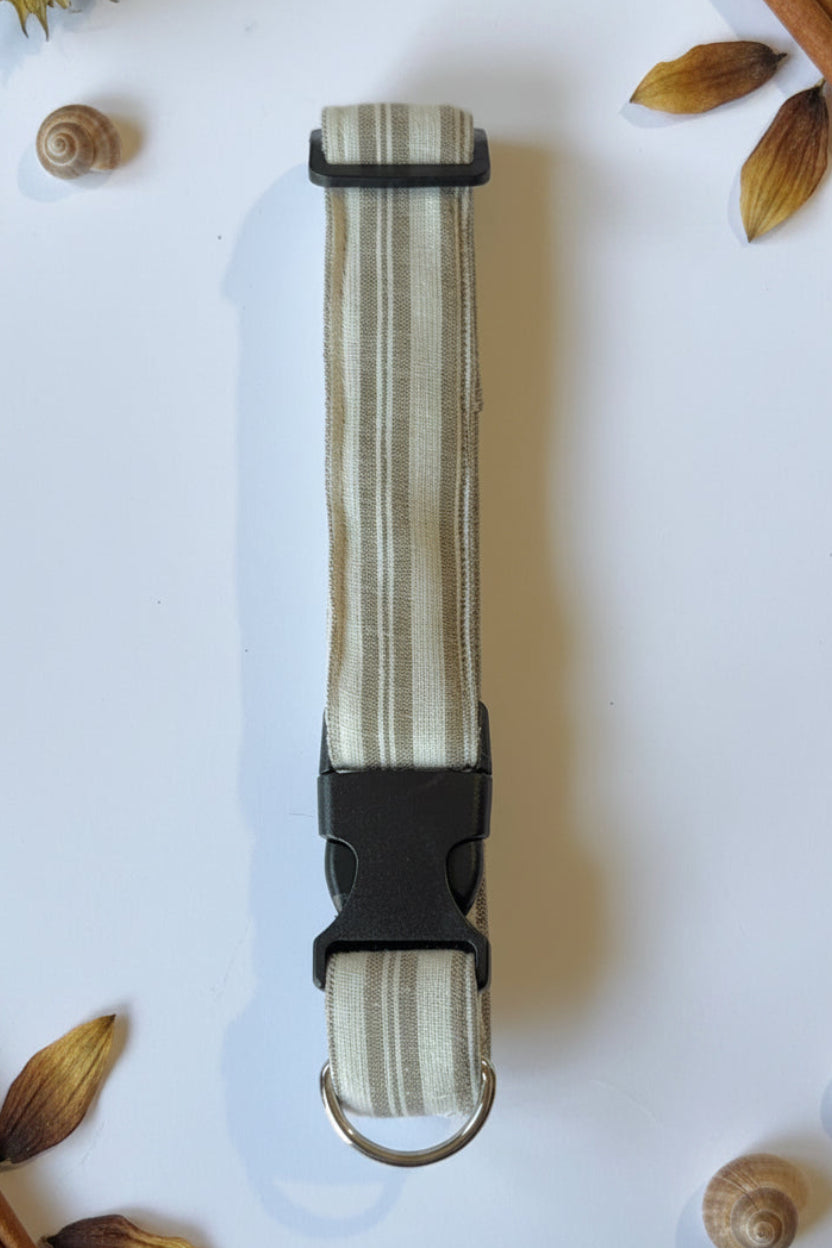 dog colllar with brown and beig verticle stripes  with a black buckle and silver d-ring 